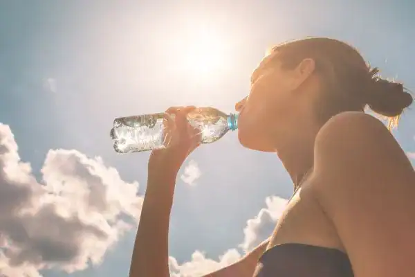Hydration: The Secret Ingredient for a Toned Stomach and Enhanced Fitness 3 Image of woman drinking water to hydrate Paisley after run.